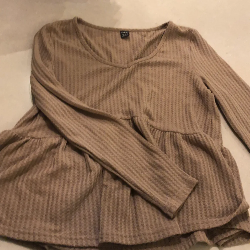 Långärmad brun tröja i storlek M. Med en liten volang ner till.. Tröjor & Koftor.