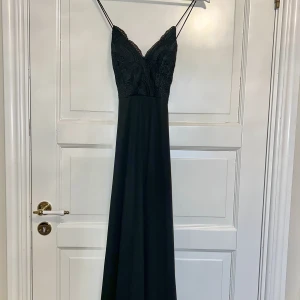 Svart balklänning  - Svart lång balklänning i storlek 36 med spets upptill på framsidan. Klänningen är från Chiara Forthi Milano och har korsade band på baksidan. Klänningen är endast använd en gång så att den är i väldigt fint skick. 