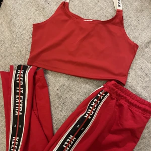 Set med zipperbyxa - Set från Antonija Mandirs kollektion med Madlady. Superfint skick, använd enstaka gång. Cool detalj med zipper på sidan av benen som går ända upp till höften. Söm mitt fram på byxbenen. Lågmidjade