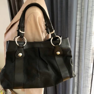 DKNY - Jättesnygg svart DKNY väska. Jättefint skick. Den är 40cm bred o 29cm hög. Har flera fack inuti, rymmer mycket