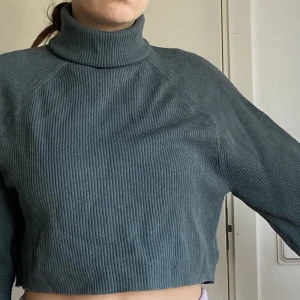 Stickad tröja från bikbok - Supersnygg grön/blå tröja med polokrage och vidare armar! Den är ganska croppad, slutar typ vid naveln på mig.