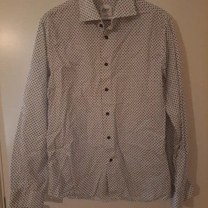 Oscar of Sweden skjorta  - Stilren skjorta med blå prickar från Oscar of Sweden,  Wrinkle free, slimfit stl L/42