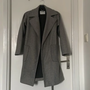 Grå kappa  - En grå kappa från new yorker i storlek 34, bra skick på kappan knappt använd , köpte den för 600kr den som köper står för frakten 