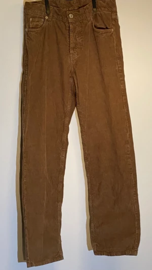 Bruna manchester byxor - Bruna manchesterbyxor från weekday i  W30. I bra shick allmänt men slitna allra längst ner på byxorna synns dock inte om man har byxorna baggy.