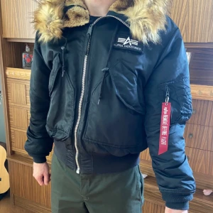 Alpha industries vinterjacka - Vinterjacka från Alpha Industries med modellen av en bomberjacka  Har endast använt en säsong och är i bra skick Pälsen på luvan går att ta av