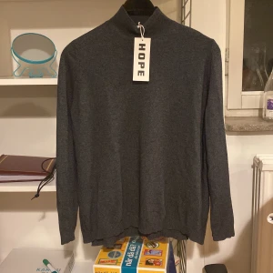 HOPE merinoull-tröja - Helt oanvänd stickad tröja från HOPE i merinoull och kaschmir. Mörkgrå i färgen. Storlek 36, normal i storleken.  Nypris 1500kr. Säljes på grund av fel storlek!