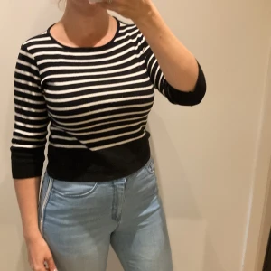 Randig finstickad tröja - Svartvit randig finstickad tröja med trekvartsärm.  Ytludd kan förekomma. Tas bort med noppmaskin.  Hel och ren. Inga anmärkningar.  Djur- & rökfritt hem.  Rensar ur min walk-in-closet, så kolla in å fynda! Samfraktar! 