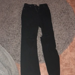 Svarta jeans  - Svarta utsvängda jeans med hål på knäna. Bra skick, ändast använda fåtal gånger. Möts gärna upp. Köparen står för frakten. Kom privat för ytligare bilder 