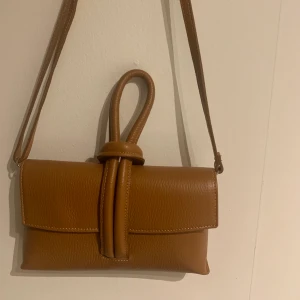 Väsk - Cool väska köpt i Italien. Aldrig använd. Kommer med ett långt band eller om man bara vill hålla den med handtaget 