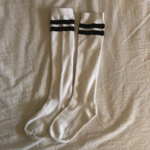 Knästrumpor med svarta detaljer  - Knästrumpor med svarta detaljer. Använda 1 gång. Lite tjockare material så passar fint under hösten och vintern. 