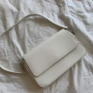 Jättefin vit handväska från Åhléns endast använd en gång på studenten, säljer pga kommer ej till användning.  Den har ett innerfack med dragkejda