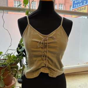 En vintage olivgrön topp med knytning - Använd men fortfarande i fint skick! Dockan på bilden är en strl S. 