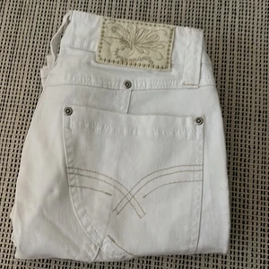 Vita jeans - Ett par super snygga vita jeans från märket ICHI, helt oanvända med lapp kvar så dem är i väldigt gott skick. mid/low rise och raka i benen med super coola detaljer. de är relativt små i storleken så skulle såga att de är mer som 27/30 istället för 29/32😊