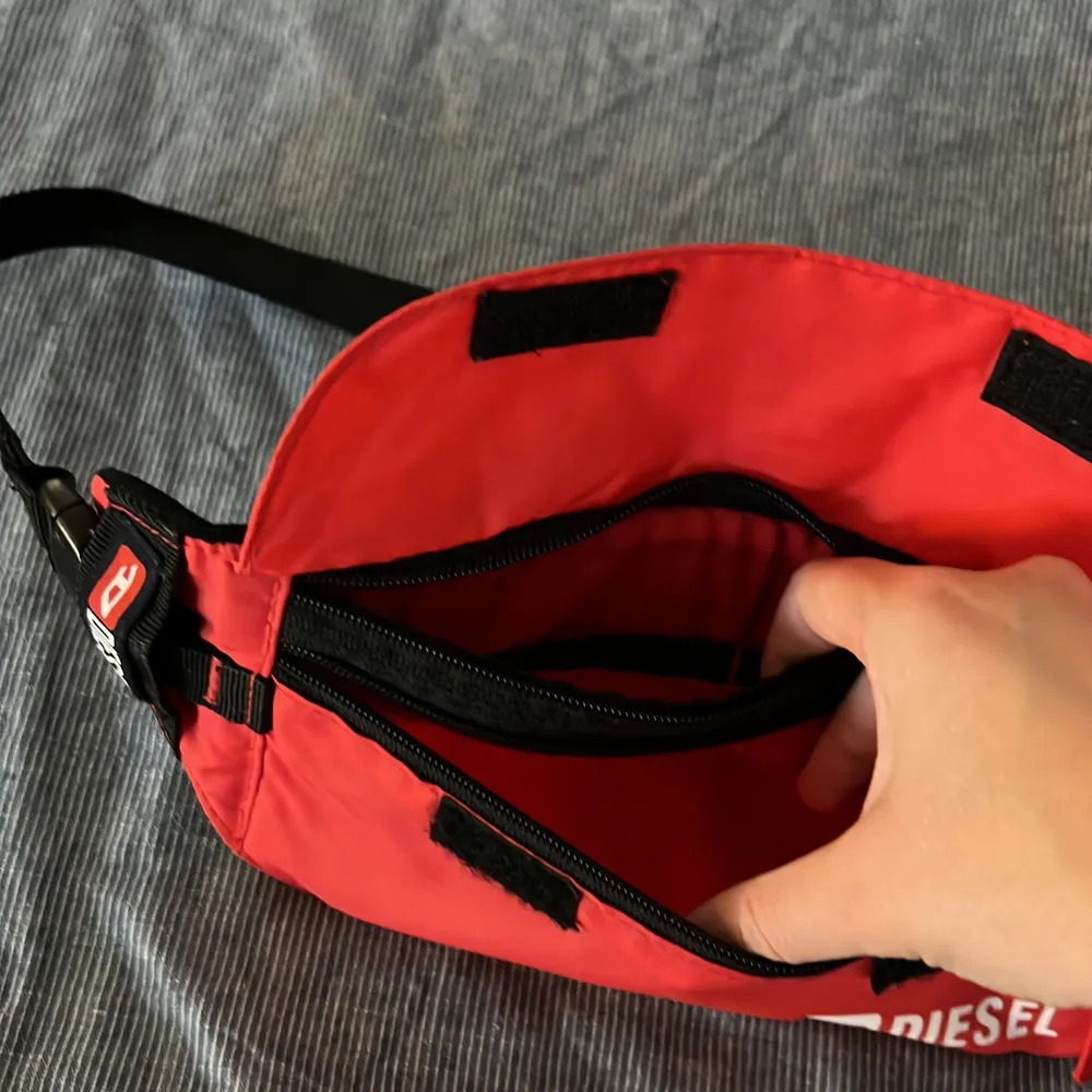Unik röd magväska från Diesel. Väskan har två fack och är i fint skick!. Väskor.