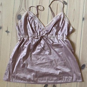 Spetslinne  - Ljusrosa spetslinne i sidenliknande matrial. Från twilfit i strl M