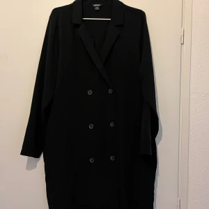 Svart kavajklänning med fickor - Super snygg svart kostymklänning i oversizemodell från Monki, har även fickor. Enbart använd vid 2 tillfällen. För mer information och bilder kontakta mig.