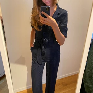 Marinblå jumpsuit - Säljer denna otroliga jumpsuit från Monki. Köpt för 2 år i Köpenhamn. Jättefin men kommer inte till användning längre. Den är även i ett mycket gott skick. Storleken är XSS men passar även en XS som jag själv är. Jag är 172cm.