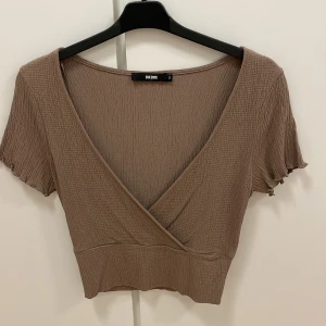 Topp från Bikbok - En jätte snygg topp i färgen gammal rosa/ lila färg. Fint material och figurnära i midjan. Aldrig använd.