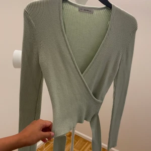 Knytbar tröja - Mintgröna ribbad tröja från NaKd. Tjockt och fint material. Man kan knyta tröjan runt midjan. Osäker på stl antigen XS eller S. Mycket strechig.