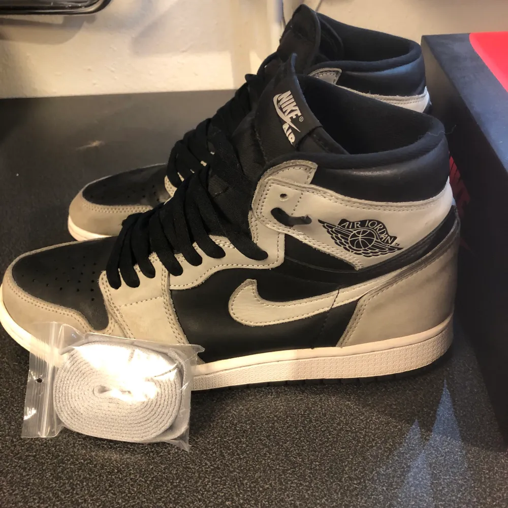 Jordan 1 i modellen shadow 2.0, storlek 44,5 Använda men i bra skick, köpta från SNS Ingår orginalbox och oanvända snören. Skor.