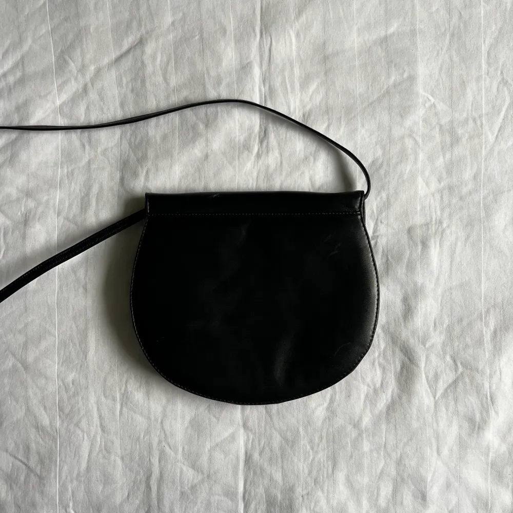 En svart rundformad väska ⚫️. Väskor.