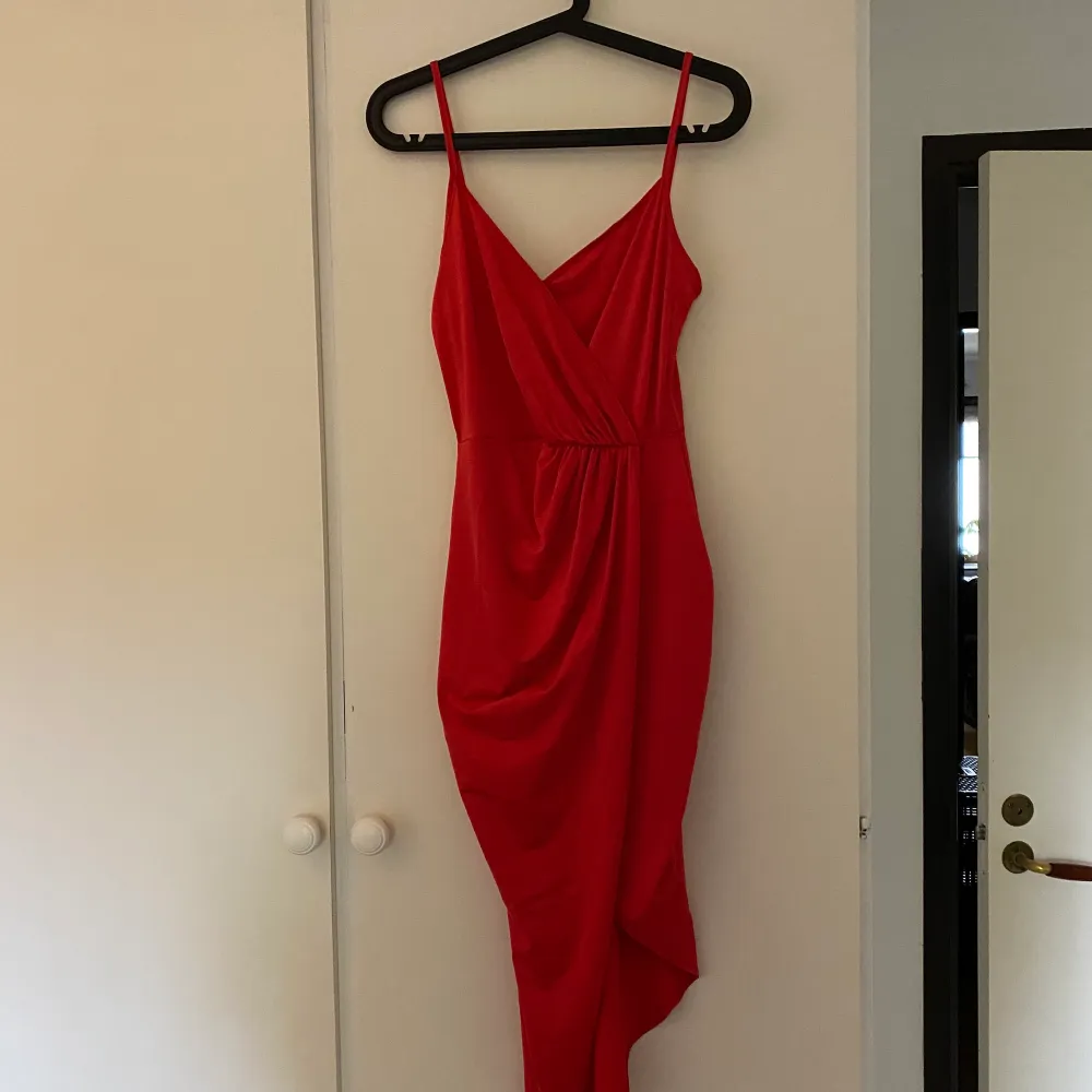 En elegant fin röd klänning från Nelly. Enbart använd 1 gång. Sitter jättefint på kroppen och ger en fin figur. . Klänningar.