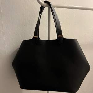 Den perfekta svarta handväskan till skolan eller jobb. Bra storlek där du får plats med mycket. Väldigt bra skick då den inte är använd särskilt många gånger!  Märke: H&M. Priset är inklusive frakt. 