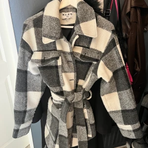 Rutig kappa  - Rutig halvlång kappa från NAKD i storlek 38  Har kemtvättats så helt ren 🫶