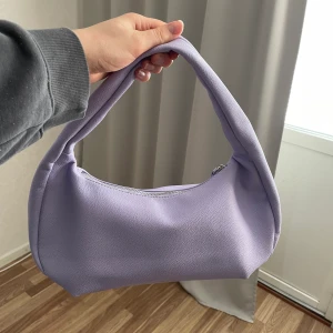 Lila handväska  - Köpt på Gina Tricot för 300 kr. Helt oanvänd! 🌺 Osäker på frakten. Köparen står för frakten. 