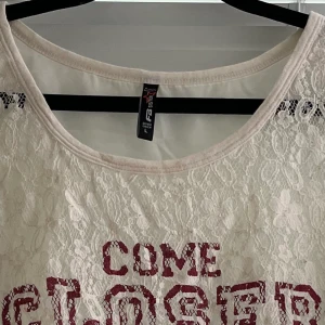 Fin seethrough tröja i spets i storlek L - En väldigt fin tröja i bra skick. 3/4 ärmar som sitter lite tajtare. Texten och ränderna är typ ”målade” på och är inte i materialet.   Jag har katt och kanin!