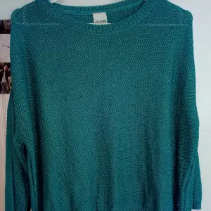 Det är en stickad blågrön tröja med en slits i bra skick. Jag har bara använt den några gånger. På andra bilden är färgen inte som i verkligheten men på första och andra bilden ser man färgen tydligt 