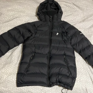 Peak performance jacka  - Vinterjacka från peak som ja köpte förra vintern. Inga defekter förutom att snöret vid baksidan nacken man har för att hänga den är sönder sen är har baksidan av högra armen en insydd lapp. Storlek S men passar även M och kanske t.o.m. L. Varm och skön.