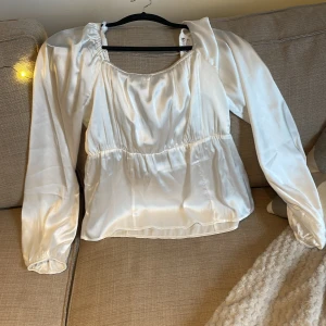 En glansig vit blus  - Storlek S och är väldigt fin med en insats midia 💕😘