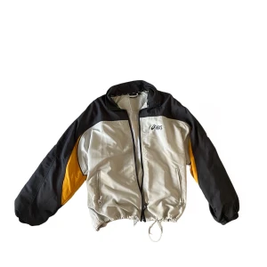 Jacka - GRÅ, VIT, ORANGE VINDJACKA FRÅN ASICS                                                     SKICK: Jackan är i bra skick och har inga defekter. 