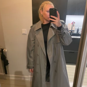 Trenchcoat  - Vintage Trenchcoat från Moores. Storlek 44 men faller snyggt oversize på mig som S