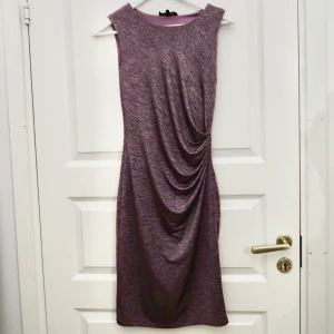 Skimrande klänning  - Klänning i storlek XS, tight modell. Stretchiga material som gör att klänningen sitter figursydd. Använd endast en gång i några timmar. Perfekt till utekväll eller något firande. Mycket fint skick och djurfritt hem. 