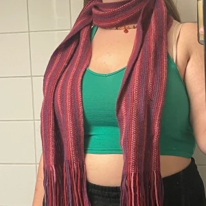 Lila/rosa stickad halsduk - !kontakta mig vid intresse av köp! Fin, stickad halsduk i röda och lila färger 