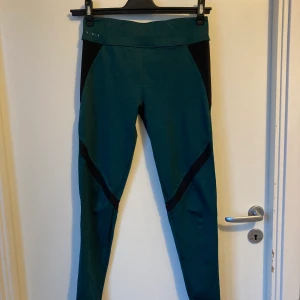 Träningstights Pull&Bear - Super sköna mörkgröna träningstights med svart mesh, säljer pga har lagt på mig lite muskler på gymmet och de passar inte längre. Är storlek L, men passar med en medium.   Köparen står för frakten om den postas!
