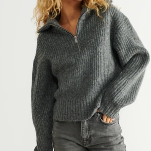 Stickad tröja - Stickad tröja med en hög krage. Tröjan är grå, långärmad och croppad. Den har en halv dragkedja upptill.  Väldigt fin men kommer inte till användning i mi. Garderob så hoppas den kan göra det i någon annans🥰