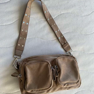 Connie väska från Gina Tricot - En väska från Gina Tricot i väldigt bra skick och nästan aldrig använd. Har 2 små fickor där framme sedan 2 stora i mitten som man ser. Väskan säljs inte längre i butik. Nypris 349kr Pris kan  diskuteras vid snabb affär🫶🏼