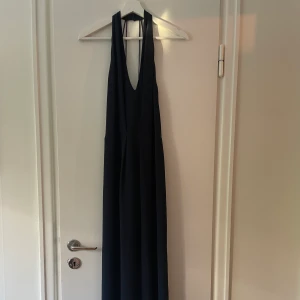Samsoe samsoe långklänning mörkblå - Fin, enkel men festlig mörkblå långklänning. För mig som är 168cm är den precis lagom lång om jag har en lägre klack, längden funkar också med högre klack på mig. Slits nere baktill, v-ringning fram och öppen rygg. Dubbla lager tyg. 100% polyester. 
