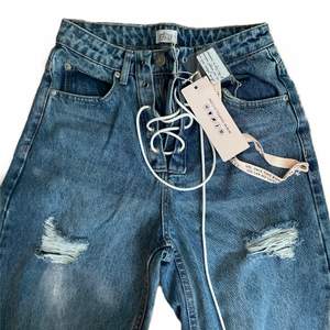 Fina jeans från ohpolly med slitningar och snörning. Aldrig använt och lapparna är fortfarande kvar🫶🏽 det är ”petite” passform i storlek 8 