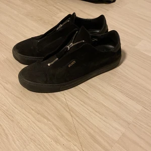 Svarta Axel Arigato skor med dragkedja - Jag säljer dessa svarta Axel Arigato skor i storlek 46. Säljer pga av att jag knappt använder de längre. De är i bra skick förutom att de har några uppskrappningar på insidan av högra skon. 