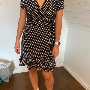 Jättefin prickig wrap-dress - Jättefin wrap-klänning perfekt för stranden i super skönt material. Säljs då den inte används tillräckligt mycket. Går att spänna åt så passar stora som små. (XL/L-S). Använd fåtal gånger!!! Väldigt ÄSLAKAD klänning!💛💛