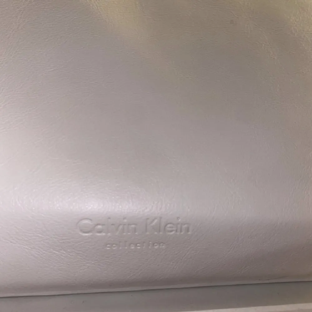 skit snygg vit handvätska vintage  från calvin clein, den är relativt stor, får plats med en mac laptop o böcker på bredden är den 41 cm,djupet är den 15 cm och höjden är 32 cm. Väskor.