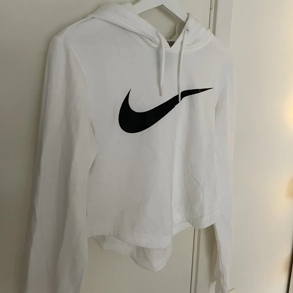 En vit tränings hoodie från Nike. Kommer tyvärr aldrig till användning. Perfekt att ha under ett gym pass, är dessutom lite kortare i modellen.. Hoodies.
