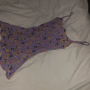 Blommig klänning - Kort blommig klänning. Använd ett fåtal gånger. Kan även användas som långt linne, jättesnyggt! 