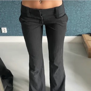 Lågmidjade kostymbyxor - Säljer dessa supersnygga lågmidjade kostymbyxor som jag köpte här på Plick men inte riktigt fått användning för. Innerbenslängd 83 cm och och midjemått tvärs över 32 cm. (Bilderna är  från tidigare säljaren) 