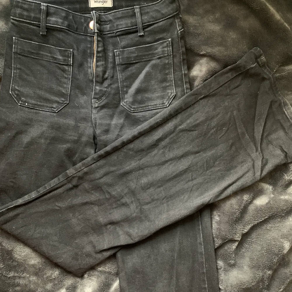 svarta flareade jeans från wrangler i modellen retro, superfina och i mycket bra skick, nästan aldrig använda! de är helt svarta men såg lite grå ut i bilderna, de är inte alls urtvättade eller så irl! skriv gärna vid frågor 🥰 nypris ca. 900kr. Jeans & Byxor.