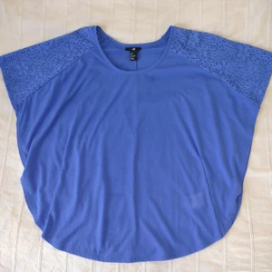 Blå/koboltblå topp/blus/poncho, strl S - Koboltblå topp med "virkade" detaljer/spetstyg. Det blå vanliga tyget är lite ludet/smånopprigt. 100% polyester. Storlek S. Använd bara ett par gånger.